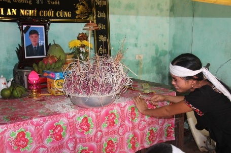 Chị Nguyệt ngã quỵ bên di ảnh của chồng