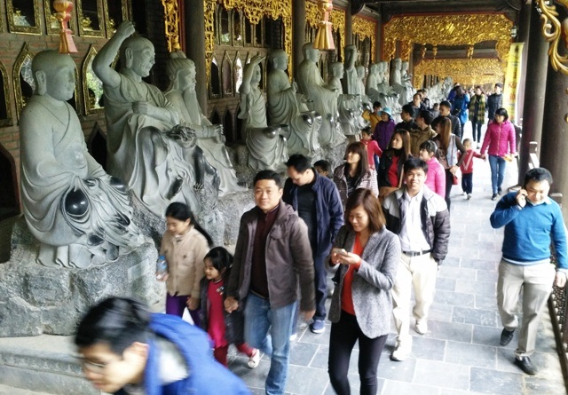 Chùa trưng biển cấm, khách vẫn sờ tượng, “ép” Phật nhận tiền - 2 Du khách, phật tử từ khắp mọi miền tổ quốc và nước ngoài đổ về ngôi chùa lớn nhất Việt Nam này để chiêm ngưỡng nhiều kỷ lục Châu Á và Việt Nam. Trong ảnh du khách đang tham quan Hành lang La hán với nhiều kỷ lục tại chùa Bái Đính.