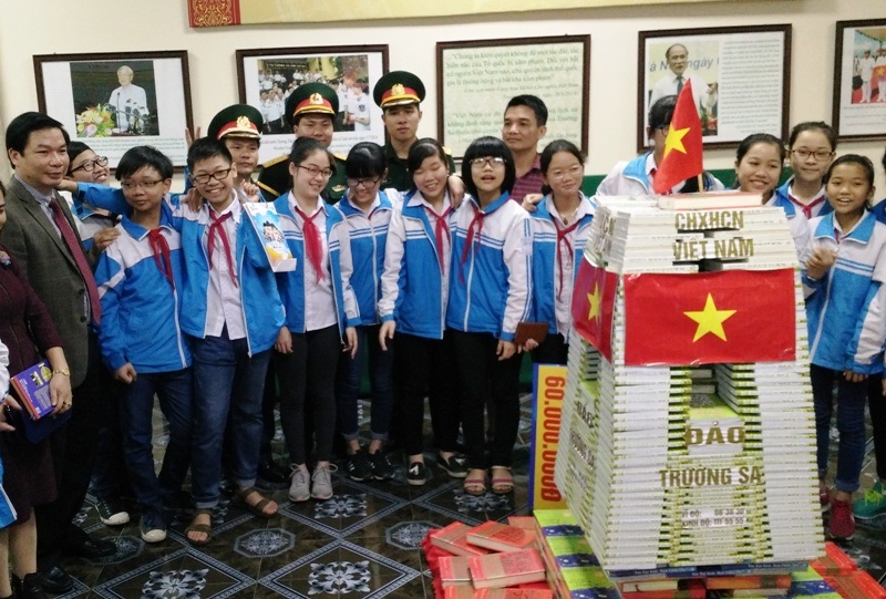 Khơi dậy lòng yêu nước cho học sinh qua “bản đồ chủ quyền” - 3 Các em học sinh chụp ảnh lưu niệm bên mô hình cột mốc chủ quyền được dựng bằng những cuốn sách viết về biển đảo thiêng liêng của tổ quốc