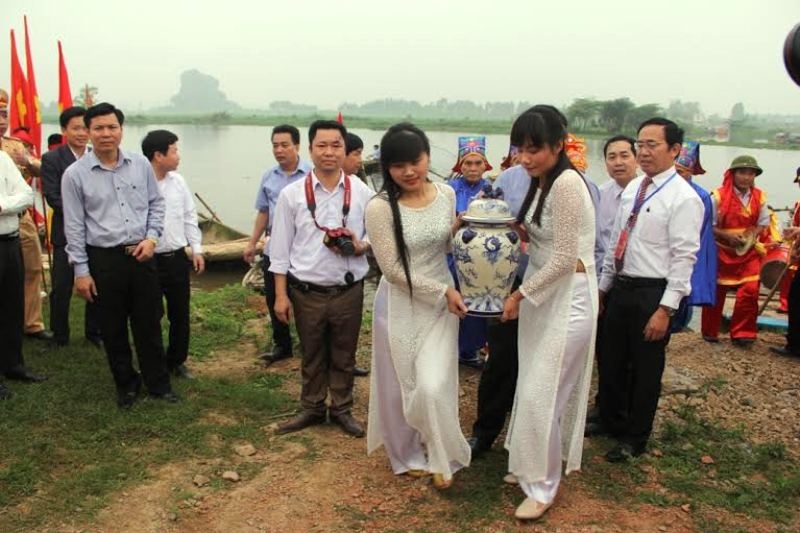 Độc đáo nghi lễ rước nước dâng vua Đinh Tiên Hoàng - 7 Khi lên đến bờ sông, hai thiếu nữ sẽ khiêng vò nước lớn cùng đoàn đi phía sau hướng đến chiếc kiệu để sẵn, sau đó đặt bình nước vừa lấy dưới sông Hoàng Long lên kiệu. Đoàn kiệu 8 người khiên sẽ rước nước về đền thờ hành lễ