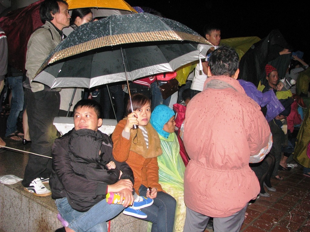 Cả nhà che mưa chờ xem pháo hoa 