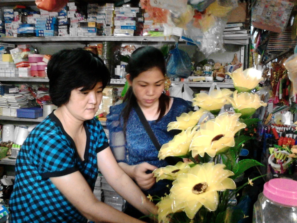 Cô Hằng ( bên trái) đang chỉ dẫn khách cách cắm hoa