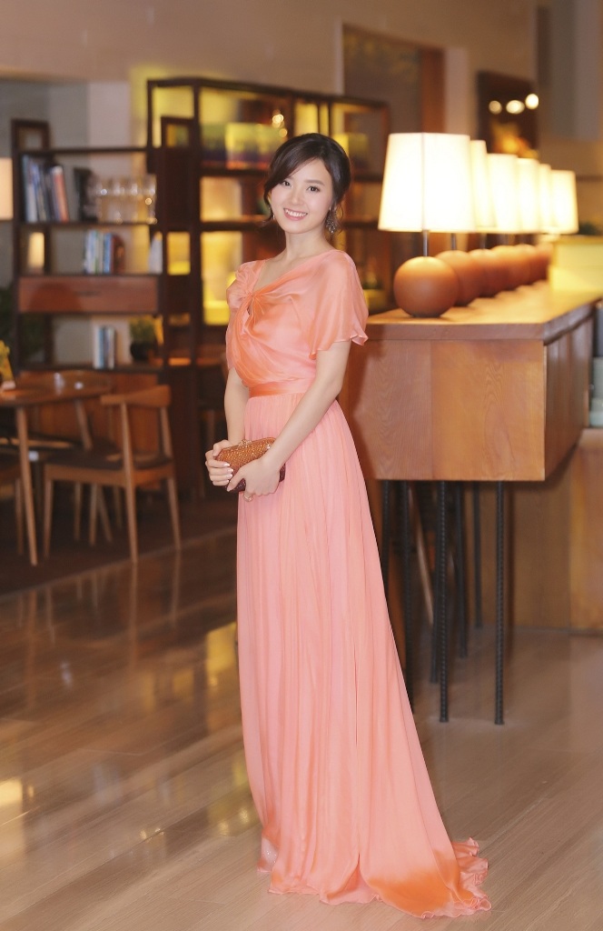Xuất hiện tại sự kiện, Midu lộng lẫy và sang trọng với chiếc đầm dạ hội màu cam được thiết kế khá thướt tha, thanh thoát tạo sự dịu dàng và yêu kiều.