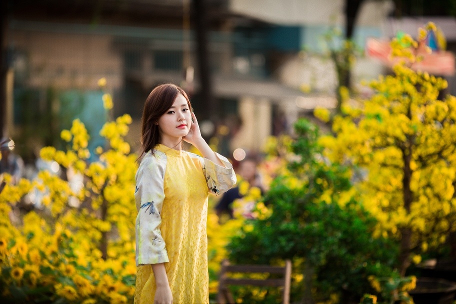 
Áo dài màu vàng kết hợp sắc trắng và hoa văn đơn giản nhưng vẫn toát lên sự sang trọng
