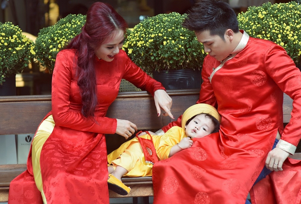 Con trai 1 tuổi của Diễm Hương đáng yêu với áo dài, khăn đóng - 1
Vợ chồng Diễm Hương hạnh phúc bên con trai trong dịp năm mới.