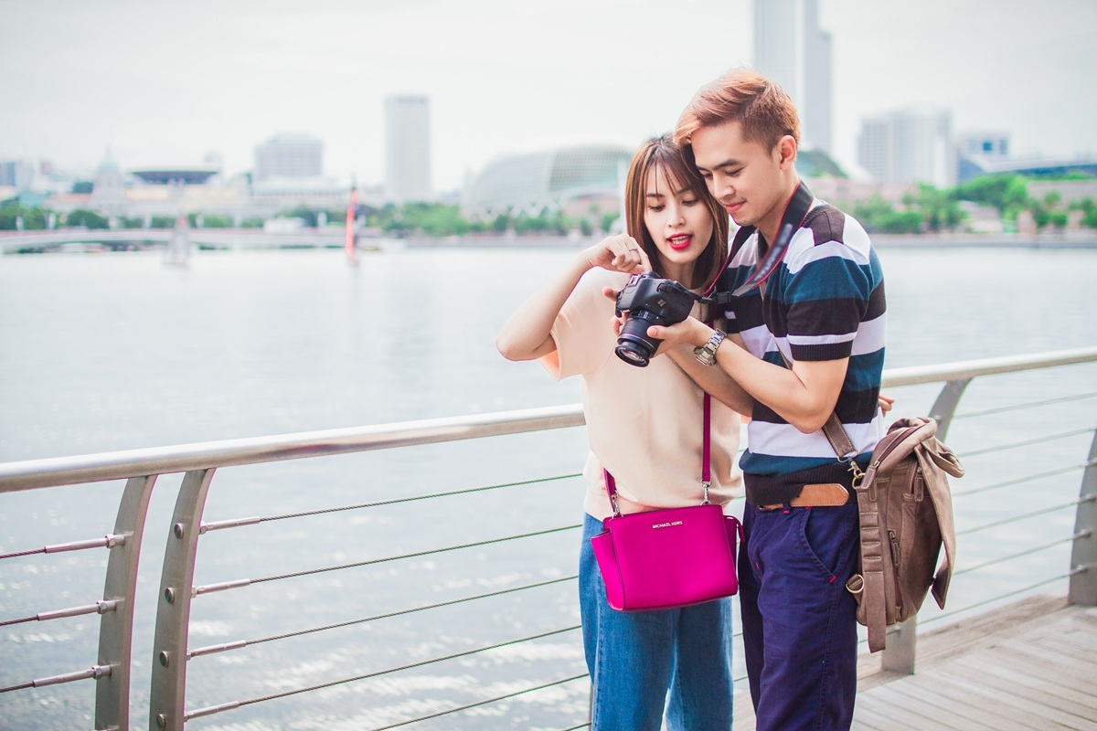 Vợ chồng Văn Anh và Tú Vi tình tứ trên đảo quốc sư tử - 5 Hai vợ chồng chăm chú xem những bức ảnh vừa chụp đồng thời chia sẽ cách chụp.