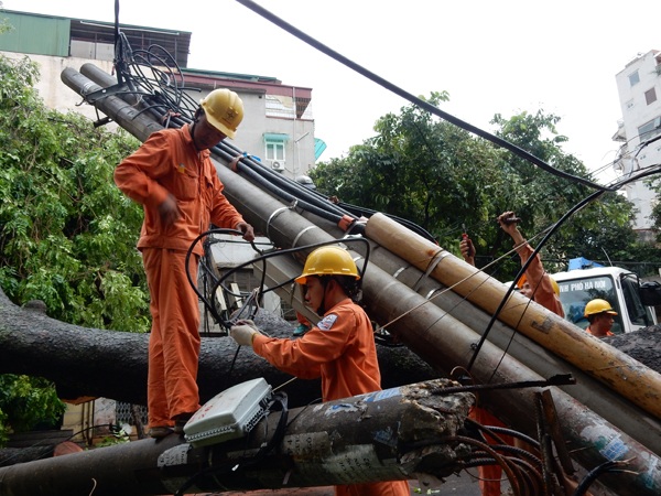 Đến 17h30 Ngày 28/7/2016 mặc cây đổ chưa được chặt hạ nhưng anh em công nhân Công ty Điện lực Hai Bà Trưng đã khẩn trương tháo dỡ thu dọn để tiến hành dựng lại cột mới - Ảnh chụp trên Phố Trần Xuân Soạn