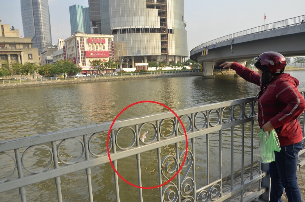 Người phụ nữ thả cá khi túi nilon chưa được mở