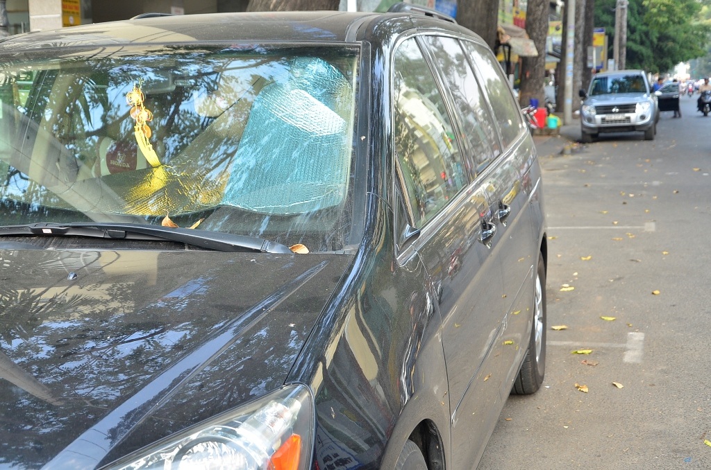 Một tài xế đánh xe đến khu chợ phụ tùng để tìm mua lại cặp kính chiếu hậu