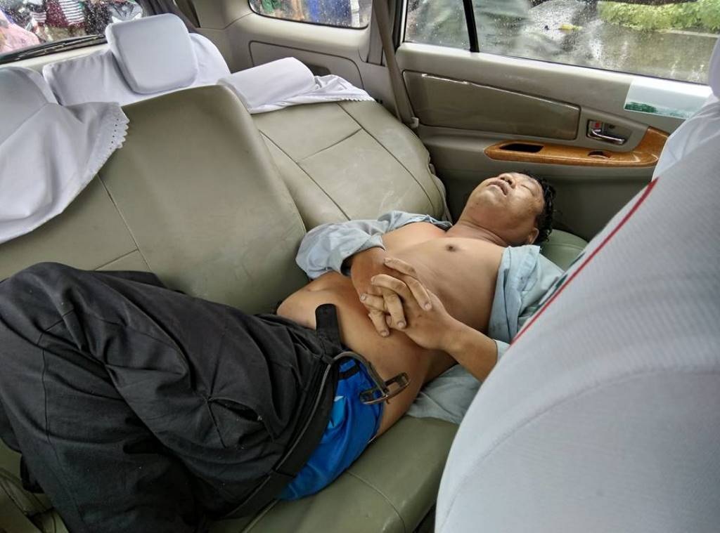 Hàng loạt cây xanh bật gốc đè trúng người đi đường - 2 Người đàn ông bị cây đè trúng được người dân đưa lên xe taxi chuyển vào bệnh viện cấp cứu