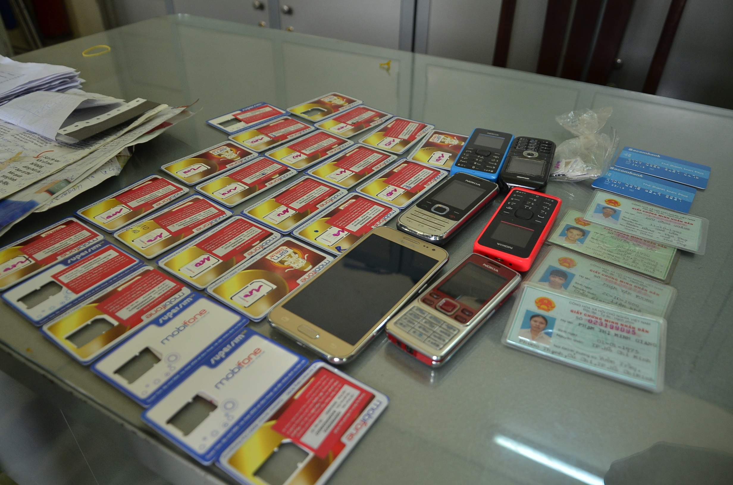 Giấy chứng minh nhân dân cũ và thẻ ATM mà công an thu giữ trong vụ giả danh Việt kiều lừa đảo mới đây