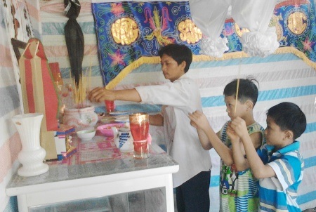 Vụ sản phụ tử vong ở Cà Mau: Trả lại giấy chứng sinh vì sai thời gian sinh - 1 Cha con anh Cao Văn Tư đang thắp hương trên bàn thờ chị Cao Thị Liêu.
