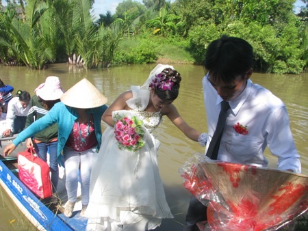 Thú vị cảnh rước dâu ở vùng sông nước miền Tây - 23 Đoàn rước dâu về tới nhà trai, chú rể lại cẩn thận dắt cô dâu từ vỏ lãi lên bờ.
