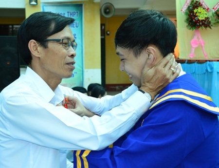 
Các em trân trọng cài những bông hoa cho đấng sinh thành.
