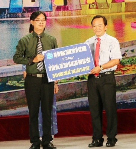 Nhạc sĩ Nguyễn Quang Vinh- Phó Chủ tịch TT Hội Âm nhạc TPHCM (trái) trao tặng bảng tượng trưng 25 ca khúc viết về Bạc Liêu cho đại diện lãnh đạo Sở VH-TT&DL tỉnh Bạc Liêu.