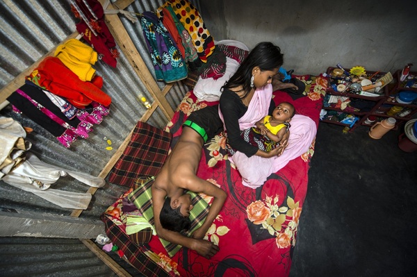 Số phận những cô gái bán hoa trong nhà thổ lâu đời nhất Bangladesh - 9 Kajol bế đứa con Mehedi mới 6 tháng tuổi của mình, bên cạnh là một người khách đang say ngủ