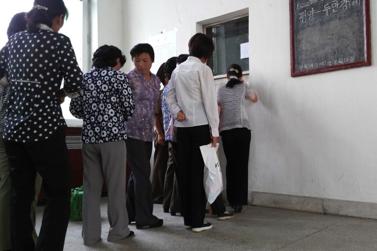 Người dân xếp hàng chờ mua vé tàu.