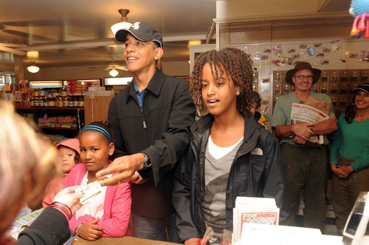 Khoảnh khắc tuyệt vời của gia đình Tổng thống Obama trong các kì nghỉ - 11 Vào tháng 8/2009, các cô con gái đã được bố mua cho snack khi họ ghé thăm cửa hàng Alley’s General ở West Tisbury, MA.