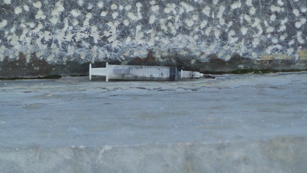 
Xung quanh tượng đài kim tiêm, xi lanh vứt ngổn ngang.
