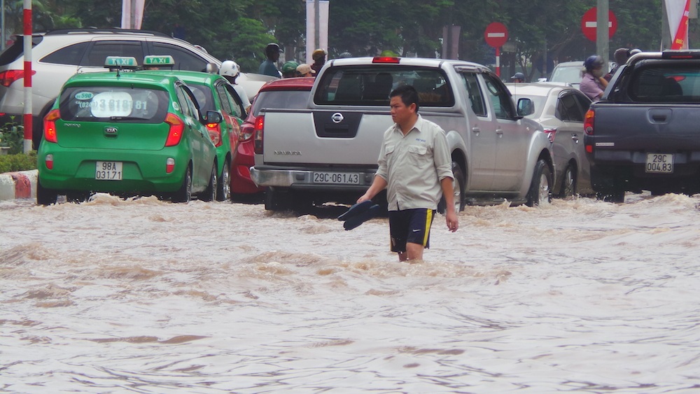 
Công nhân của Xí nghiệp thoát nước số 2 rất vất vả trong việc khơi thông cống thoát nước. Họ mặc quần đùi lội trong dòng nước bẩn để hướng dẫn cũng như cảnh báo các phương tiện tham gia giao thông.

