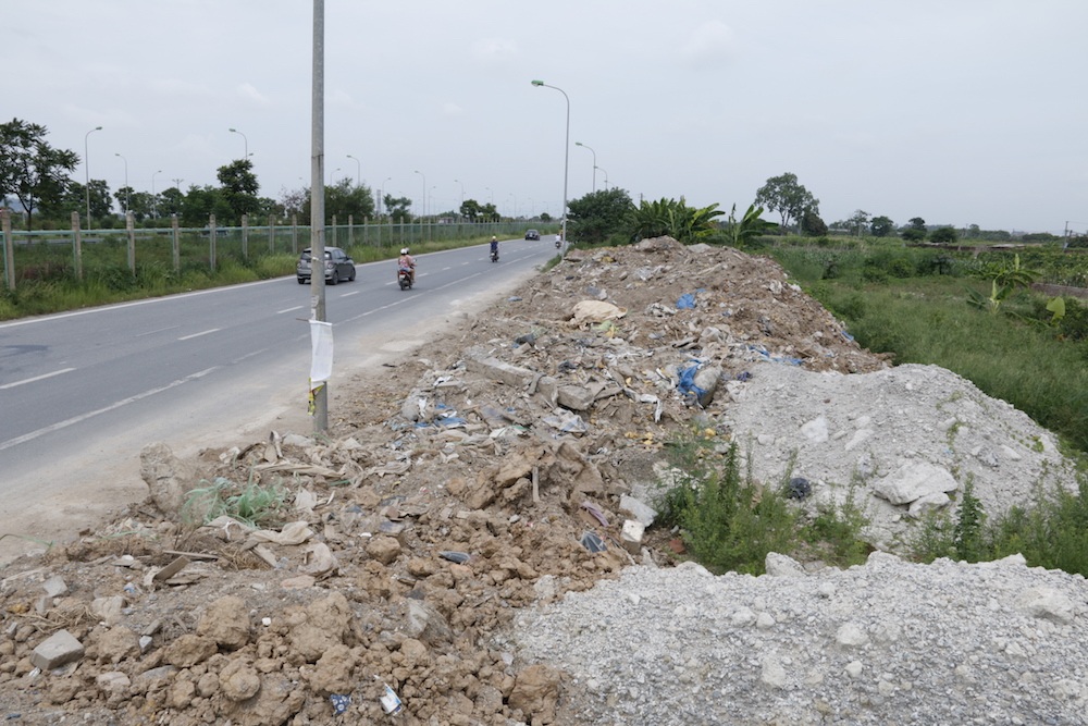 
Một bãi phế thải xây dựng bên đường gom đại lộ Thăng Long. Sau khi nhận được phản ánh, chính quyền xã đã lập biên bản xử phạt với chủ đất về hành vi tập kết vật liệu gây cản trở giao thông, đồng thời cho san ủi, trả lại lòng đường. Theo chính quyền xã Song Phương, do không bắt được quả tang đối tượng đổ trộm nên chỉ còn cách làm việc với chủ đất để lập biên bản và xử phạt hành chính, yêu cầu họ ký cam kết vận chuyển hết số phế thải này đi trong thời gian tới.

