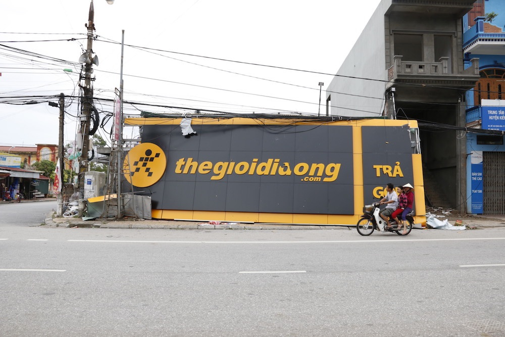 
Cả tấm biển quảng cáo lớn bị cơn bão quật văng xuống đường.
