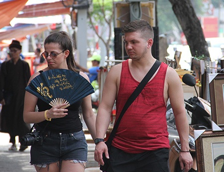 
Một du khách nước ngoài tranh thủ khi dạo phố đã tìm mua ngay một chiếc quạt giấy, được trang trí bằng những chữ thư pháp, với giá 35.000 đồng
