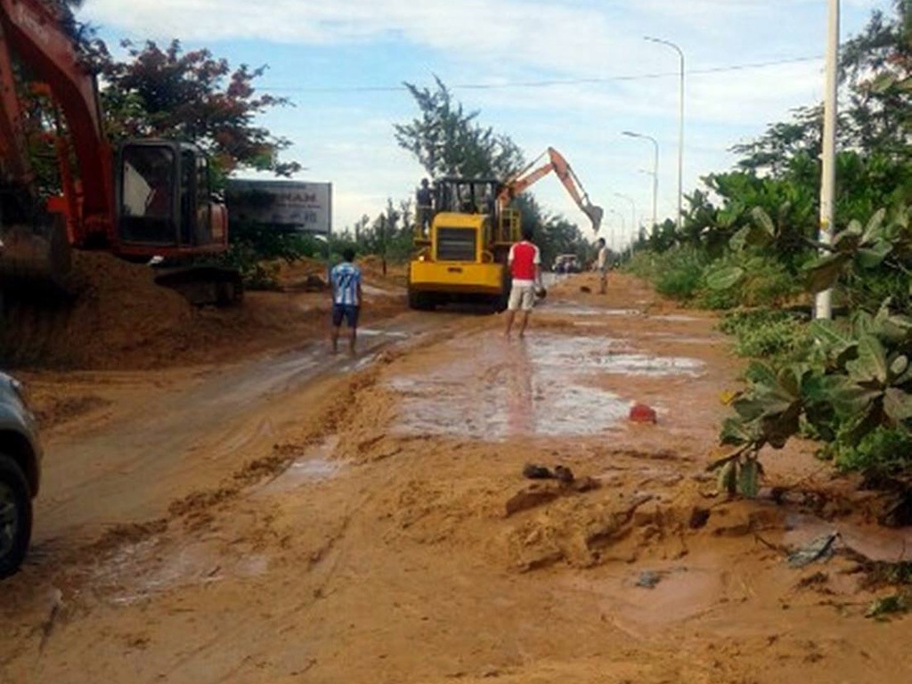 Xe ủi, xe ben nỗ lực vét bùn đỏ bủa vây nhà dân - 1 Lượng bùn khá lớn từ vụ vỡ đê tràn ra đường khiến giao thông tê liệt sáng 16/6 (ảnh: Trúc Hà)