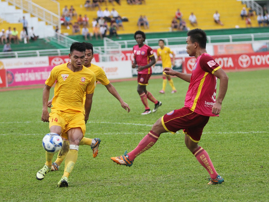 Các cầu thủ đá bóng trong bối cảnh sau lưng họ là những khán đài trống vắng, vì khán giả dần mất niềm tin (ảnh: Trọng Vũ)