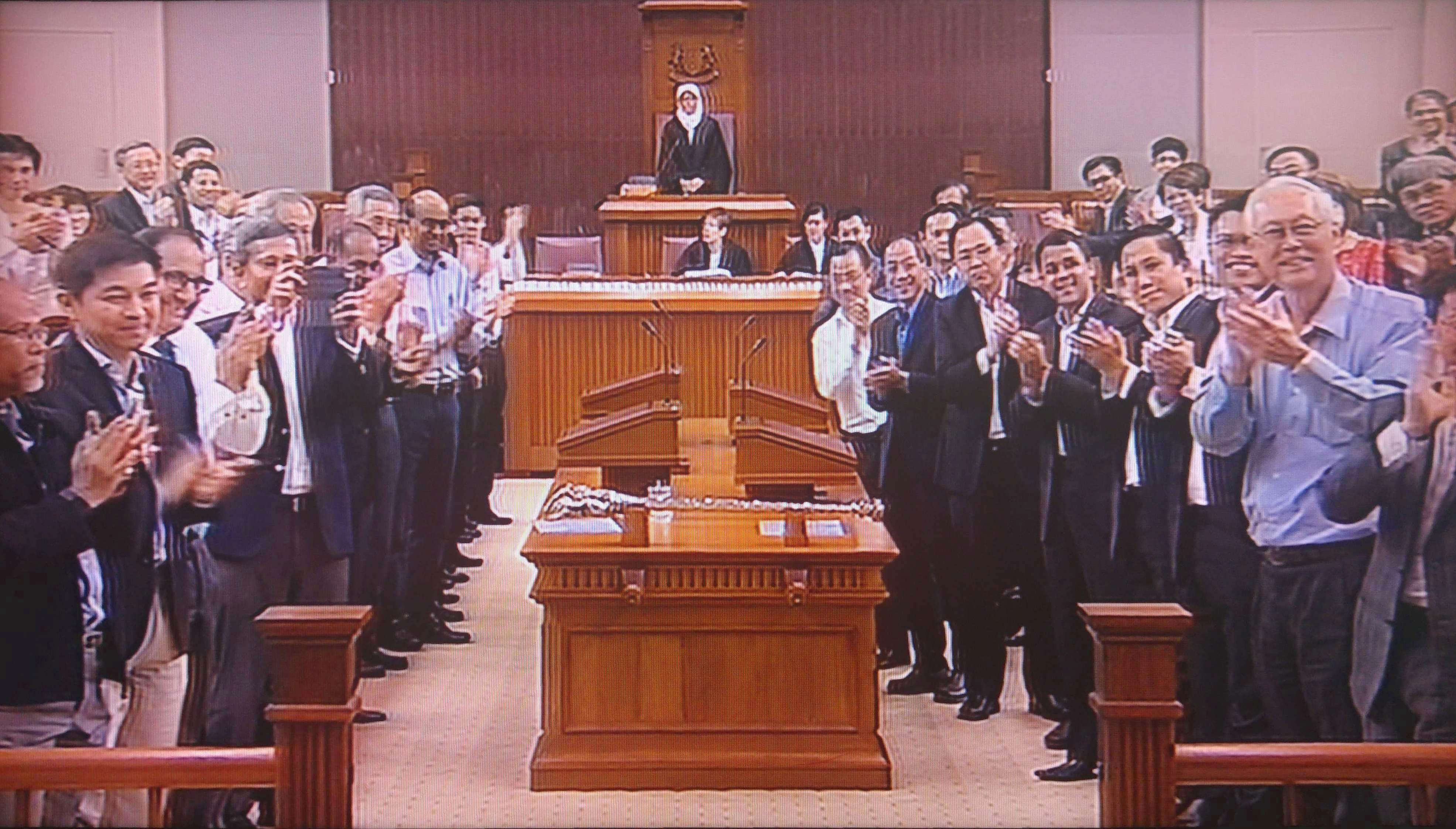 Họ được các nghị sĩ Singapore đứng dậy vỗ tay chào đón trong khoảng 30 giây, khi bước vào