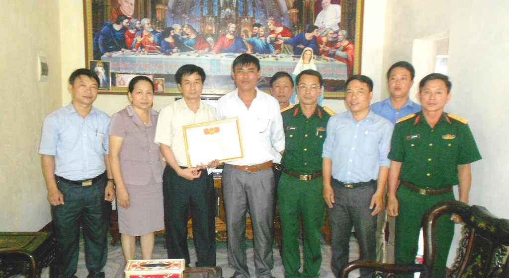 Chủ tịch UBND huyện Nghi Lộc tặng Giấy khen cùng tiền thưởng 5 triệu đồng cho ông Đậu Thành Kính và các thuyền viên tàu cá NA 90667 TS. (Ảnh: Nhật Tuấn)