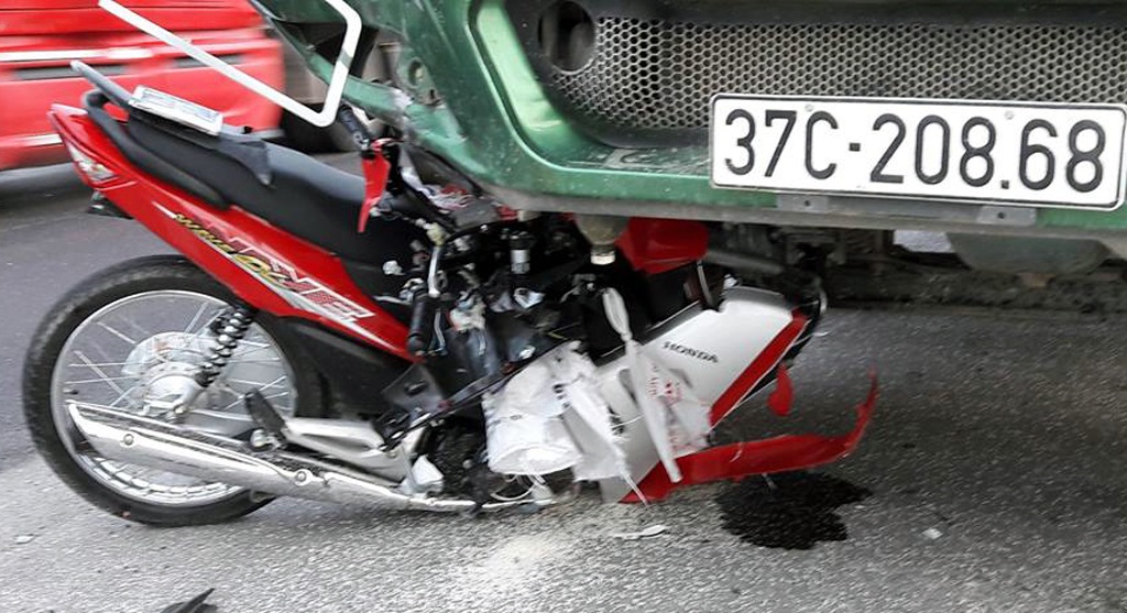 Hiện trường chiếc xe tải hổ vồ đè nát xe máy.