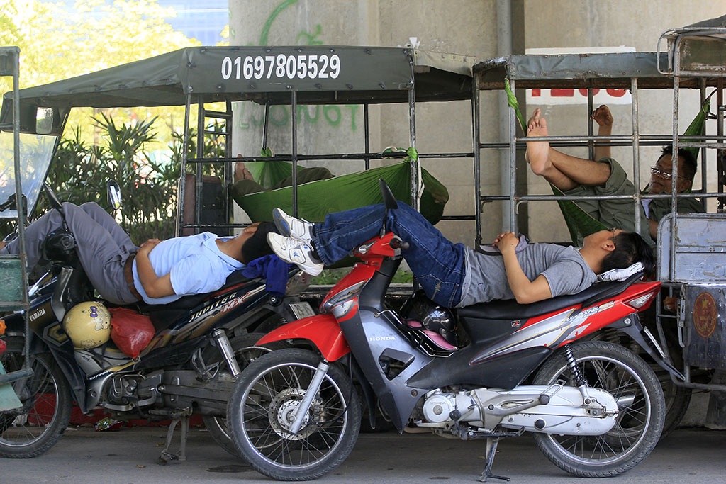 
Cánh xe ôm, xe ba bánh cũng dựa vào bóng mát từ cầu đường trên cao để tránh nắng.
