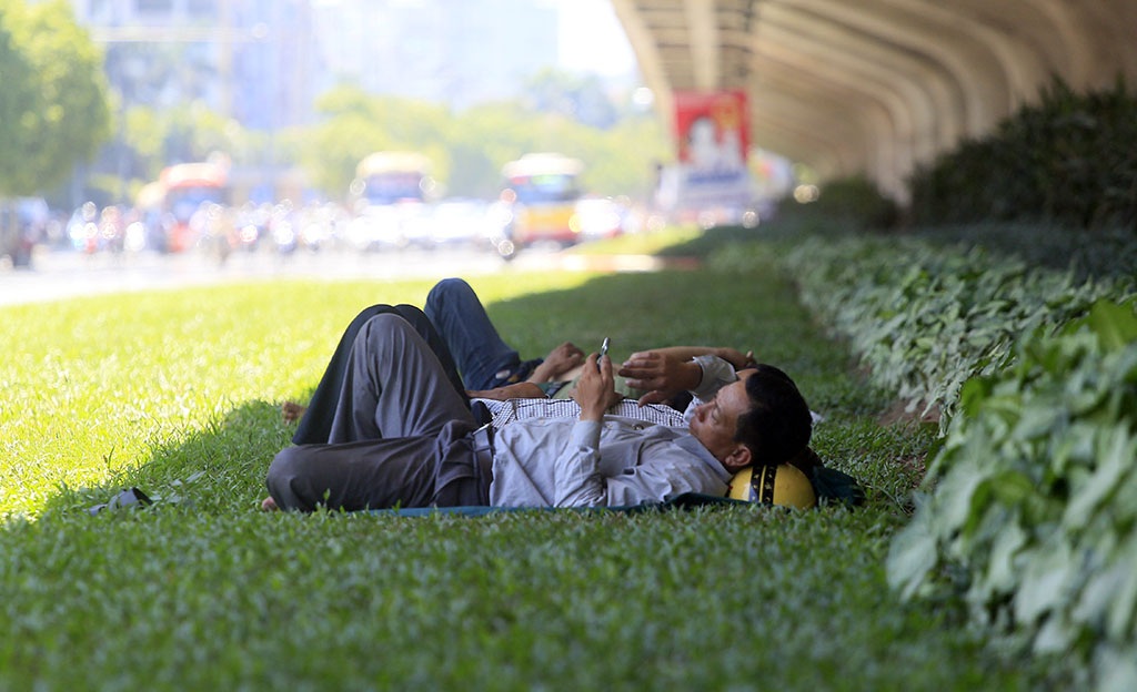 
Người dân lao động chọn thảm cỏ dưới cầu vượt đường trên cao làm chỗ ngả lưng buổi trưa.
