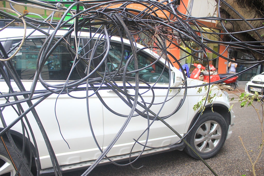 
Bó dây cáp nhì nhằng buông lơ lửng xuống đường.
