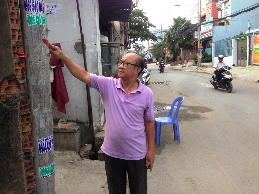 Quốc lộ nâng cao gần 1 m, nhà dân nguy cơ biến thành hầm - 1 Ông Vương Mạnh Hùng (khu phố 3, phường Hiệp Bình Phước) chỉ tay vào dấu đỏ trên cột điện là mặt đường dự kiến nâng lên của quốc lộ 13 cũ