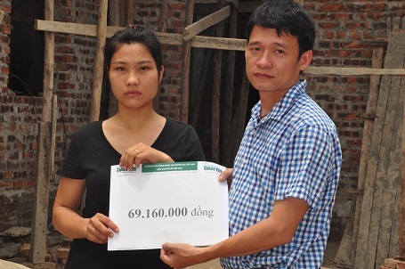 
Nhà báo Nguyễn Thế Nam, đại diện báo Dân trí trao quà của bạn đọc đến em Giang trước ngôi nhà mới sắp được khánh thành.
