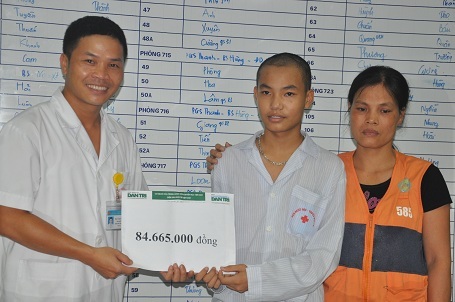 Bác sĩ Vũ Quang Hưng - Phó trưởng khoa Điều trị hóa chất, Viện huyết học truyền máu TW trao quà bạn đọc Dân trí cho mẹ con cháu Quang.