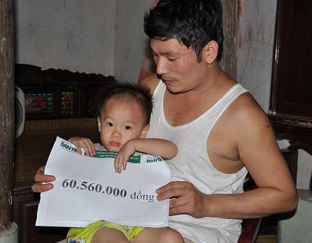 Hai bố con nhận quà bạn đọc Dân trí.