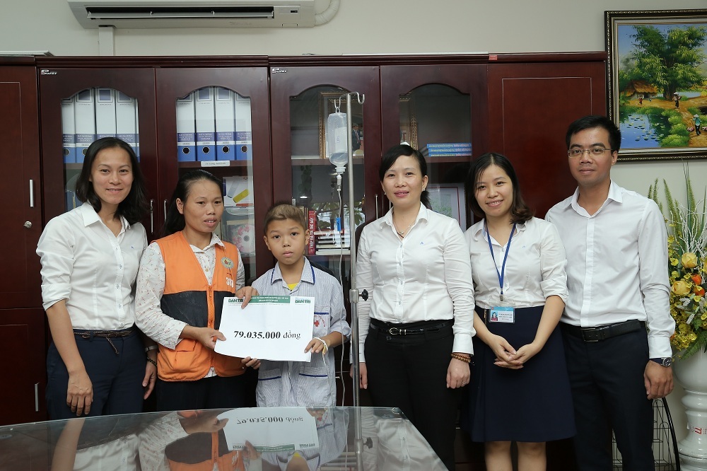 Gia đình em Hoàng Nguyễn Bảo Long nhận quà bạn đọc Dân trí.