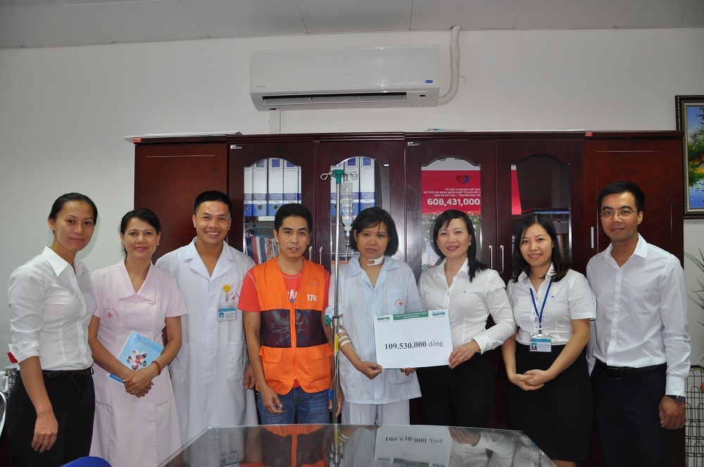 Thạc sĩ Vũ Thị Hồng Phương- Trưởng phòng tổ chức cán bộ, phụ trách phòng CTXH viện huyết học truyền máu TƯ và bác sĩ Vũ Quang Hưng - Phó trưởng khoa Điều trị hóa chất trao số tiền 109.530.000 đồng của bạn đọc Dân trí giúp đỡ cho chị Hảo.