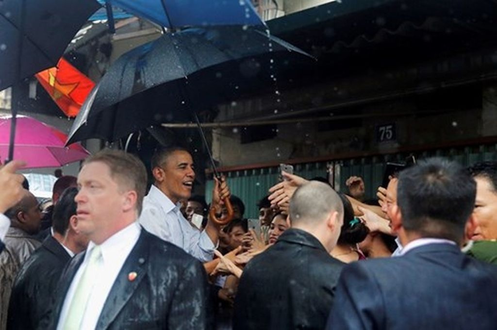 Tổng thống Obama ăn bún chả và phố phường Hà Nội biến thành sông - 2 Trước khi rời Hà Nội vào TPHCM, Tổng thống Obama đã ghé thăm làng Mễ Trì Hạ. Dù trời bất chợt đổ mưa nhưng ông vẫn rất vui vẻ bắt tay, trò chuyện với người dân địa phương (Ảnh: Reuters)