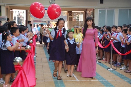“Heo vàng” háo hức ngày khai giảng - 1 Bé được cô và chị dắt vào ngôi trường mới.