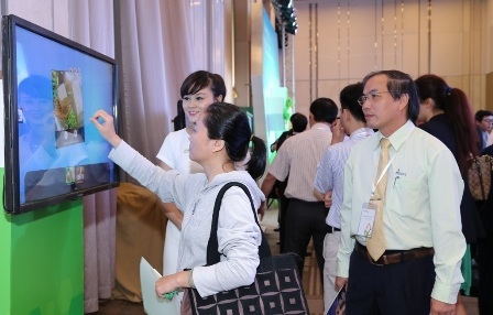 Cái nhìn mới về giá trị hạt đậu nành - 2 Khách tham dự hội thảo đang tìm hiểu về giá trị của đậu nành thông qua màn hình tương tác