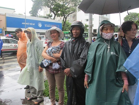 Cơn mưa bất chợt cuối giờ làm bài khiến nhiều phụ huynh bị ướt.