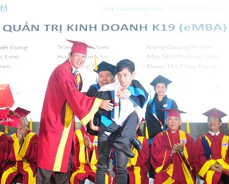 Xúc động hình ảnh tân thạc sĩ được cõng lên nhận bằng - 1 Tân Thạc sĩ Trần Thanh Sơn được cõng lên nhận bằng.