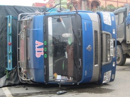 Chiếc xe tải chở hàng chục tấn thức ăn gia súc lật ngay giữa đường