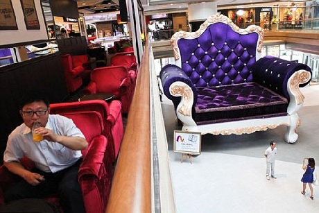 Cô gái trông tí hon bên cạnh chiếc ghế khổng lồ