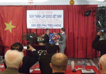 Đại sứ Nguyễn Hoằng (trái) tặng hoa cho Chủ tịch CLB Cựu chiến binh Âu Văn Yên