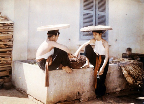 Thiếu nữ mặc áo yếm ngồi nói chuyện bên bể nước năm 1914